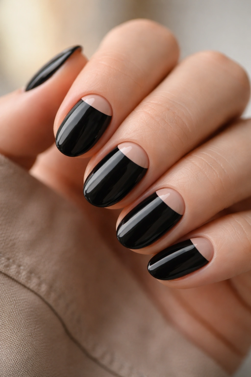 Close-up of short black nails featuring a slim half-moon near the cuticle