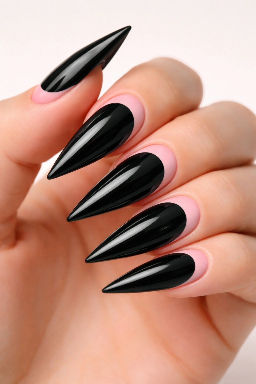 Close-up of classic half-moon black and pink stiletto nails on a bare hand