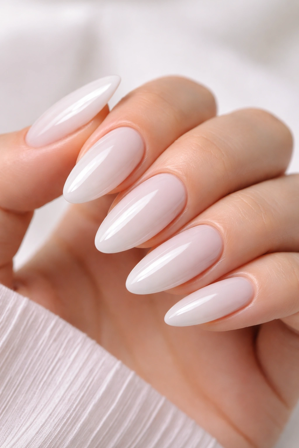 Almond milky white nails with a glossy top coat