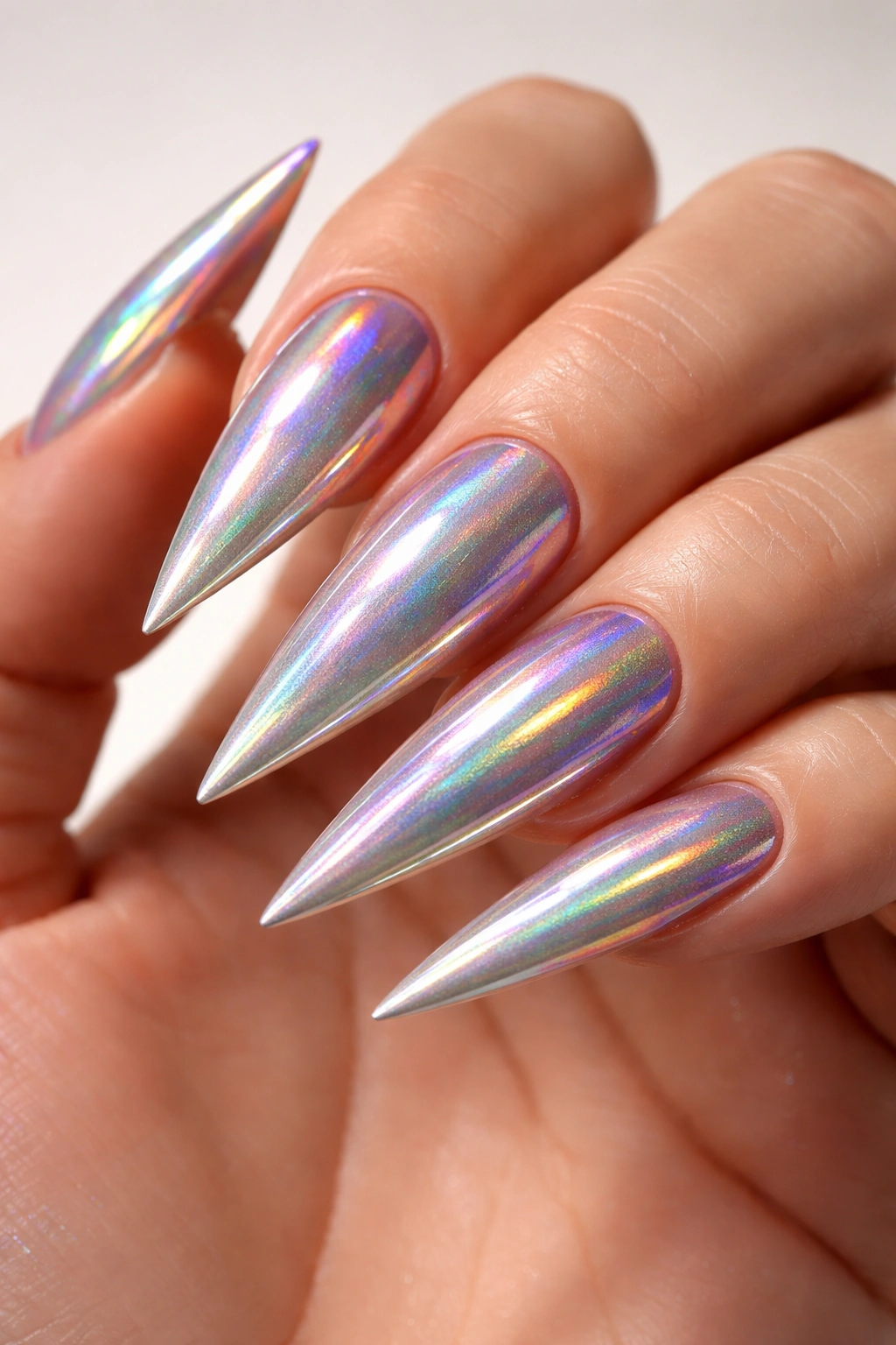 Holographic chrome stiletto nails reflecting rainbow hues