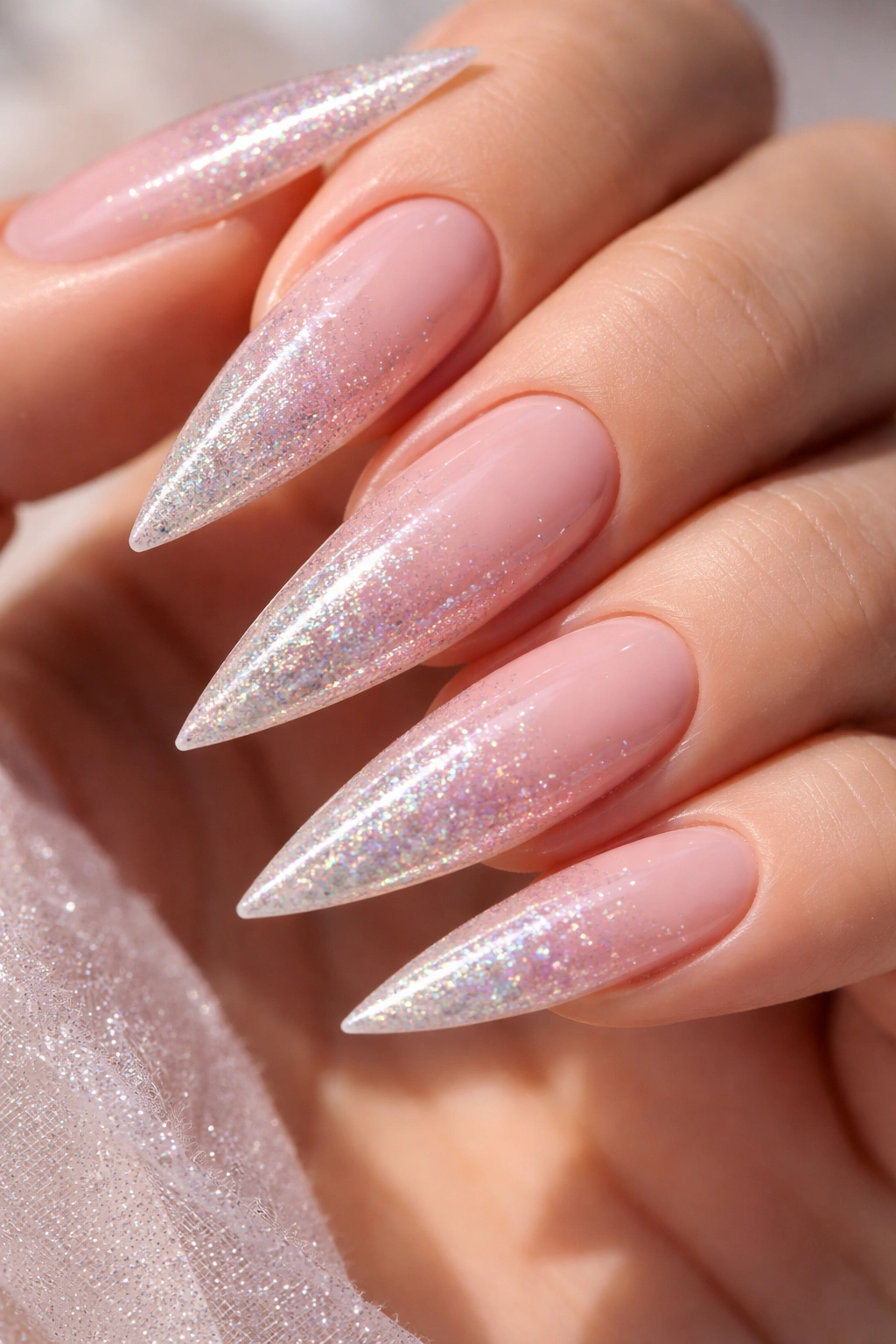Pale pink stiletto nails with holographic glitter ombre