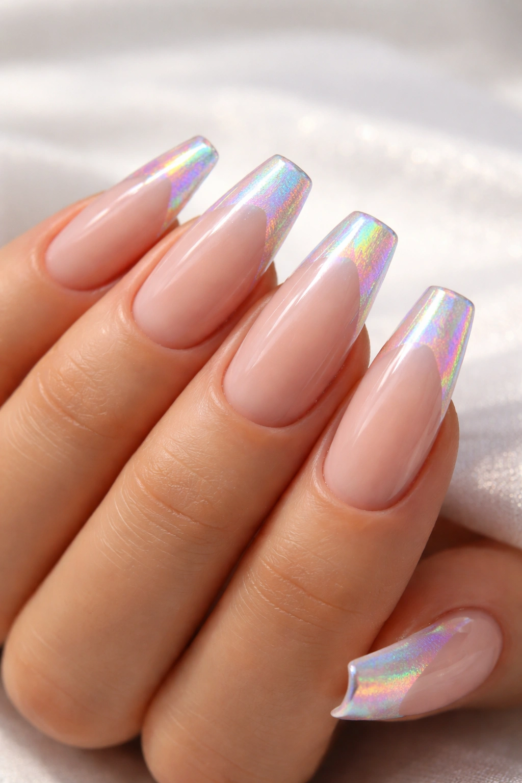 Close-up of holographic coffin nails with nude base and rainbow iridescence