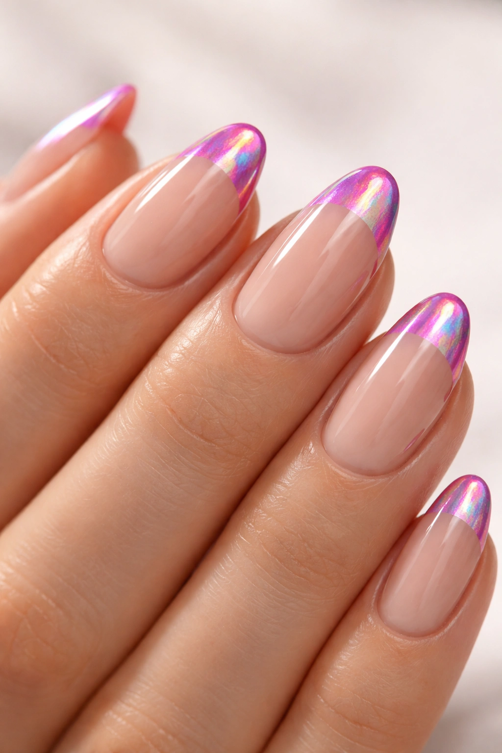 Nude-base nails with holographic hot pink French tip showing color shift.