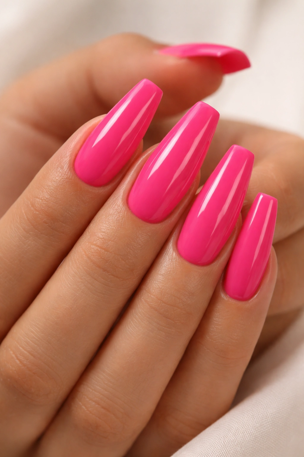 Close-up of hot pink ballerina nails with tapered sides and flat tips