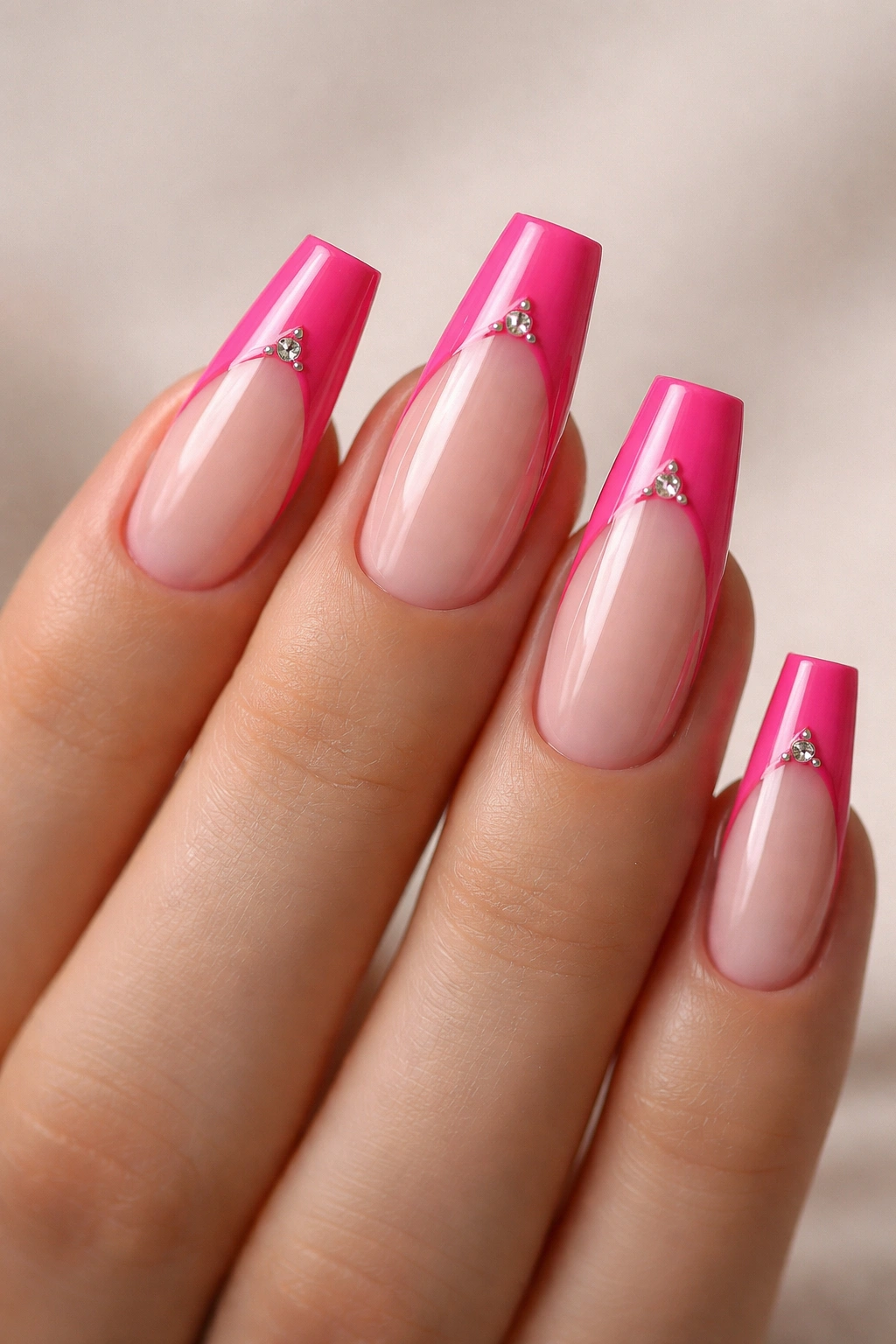 Hot pink coffin nails with negative-space French tips and small diamond details.