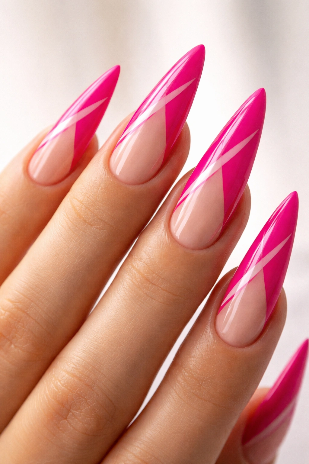 Close-up of hot pink stiletto nail with negative space design