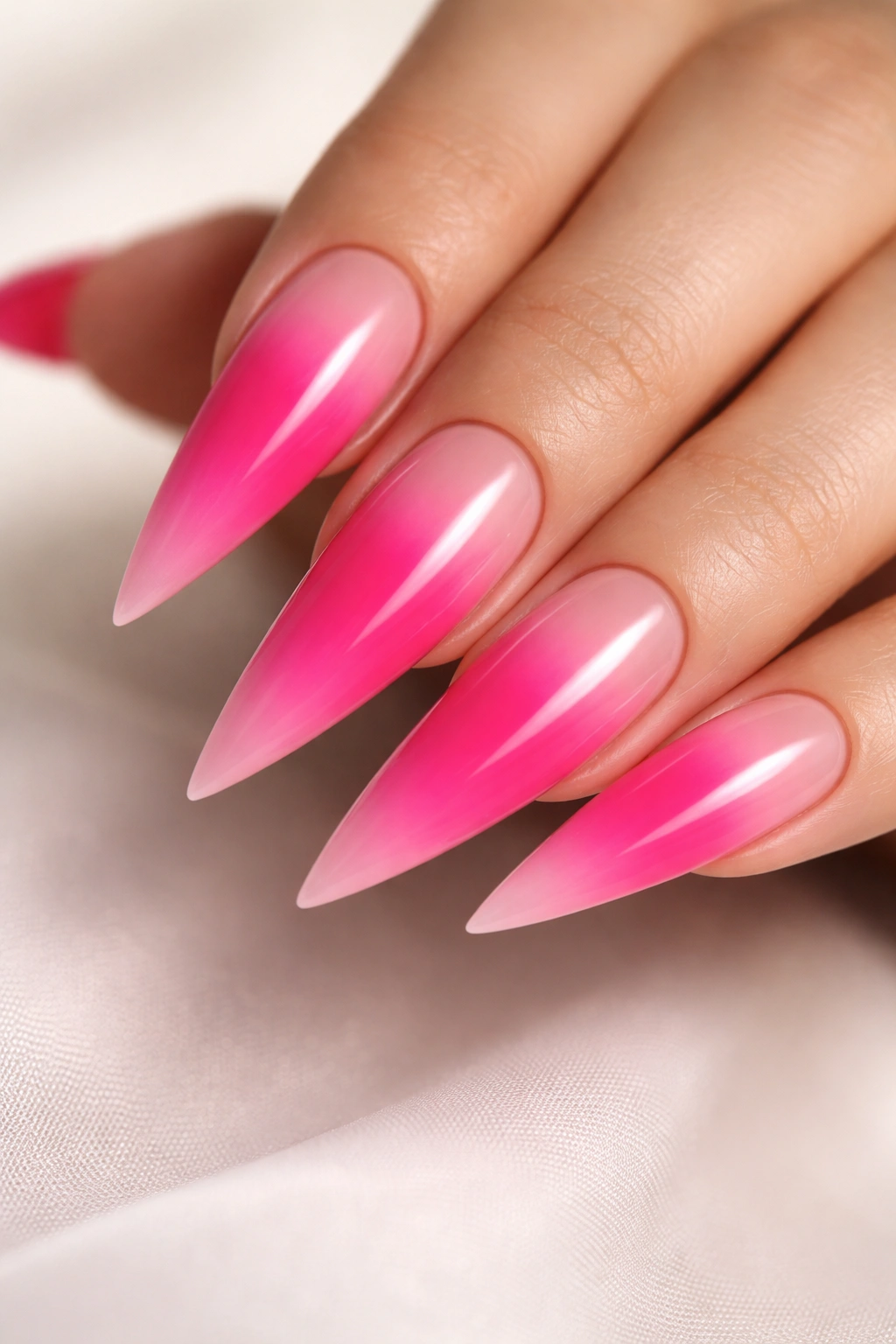 Close-up of hot pink stiletto nail with ombré to nude gradient