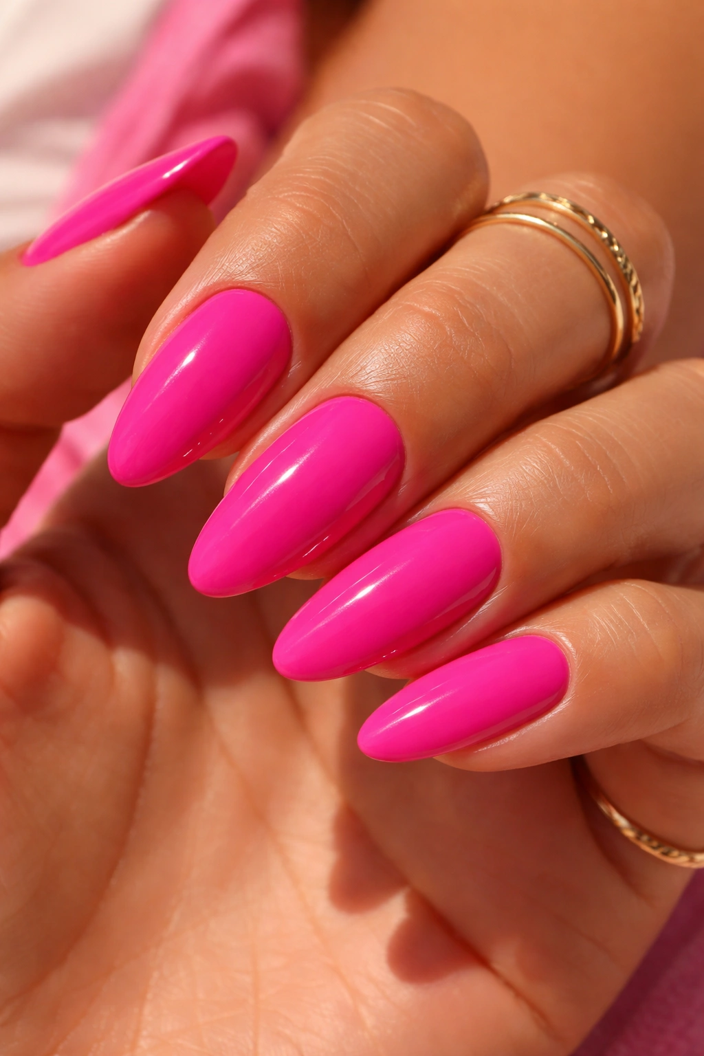 Close-up of hot pink nails on sun-kissed skin