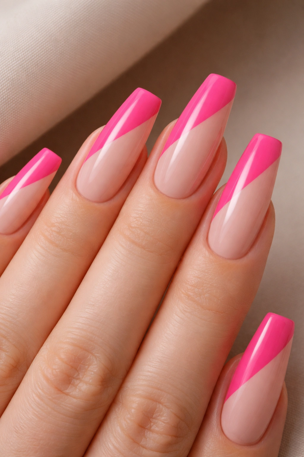 Close-up of diagonal hot pink and nude color-block nails on ballerina shape
