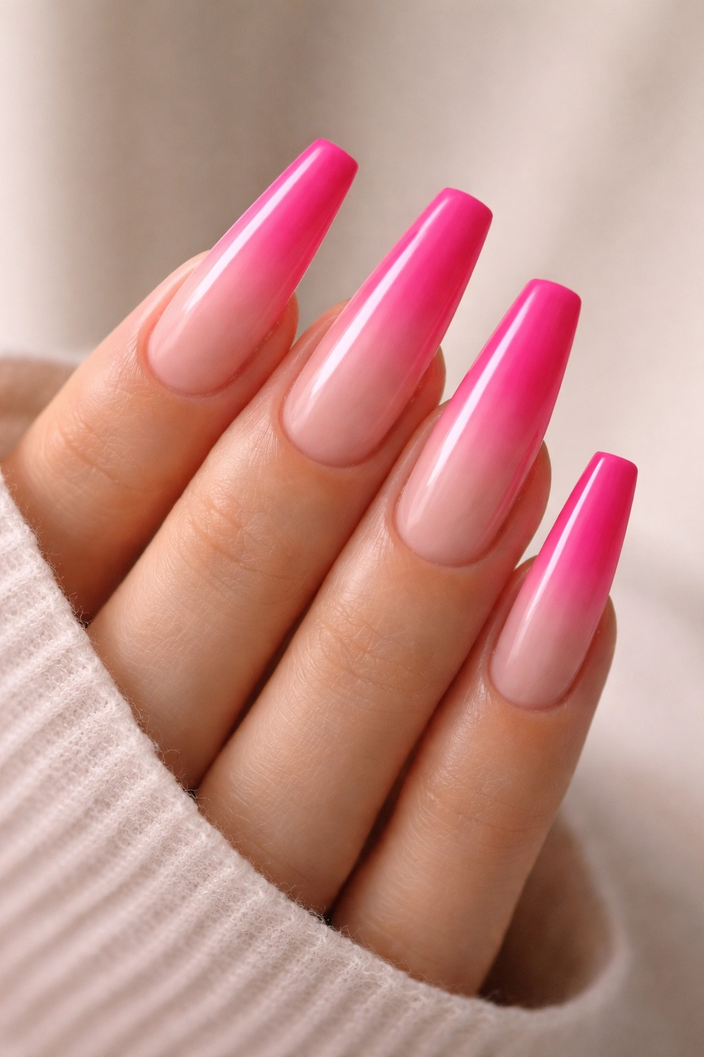 Close-up of hot pink to nude ombre coffin nails