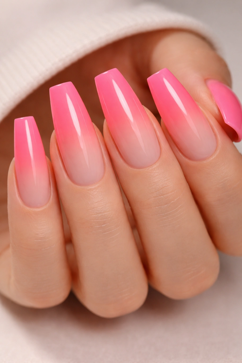 Close-up hot pink ombré neon ballerina nails on gradient