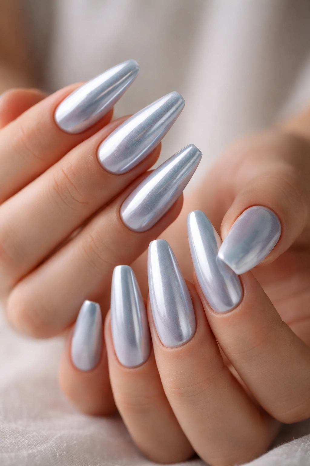 Close-up of icy blue chrome ballerina nails with frosted base