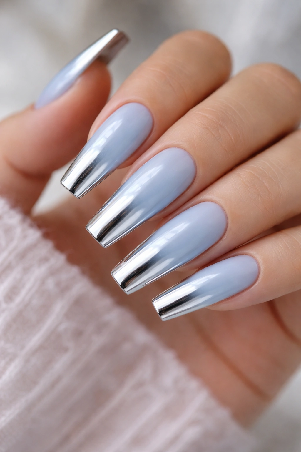 Close-up of icy blue coffin nail with silver chrome tip gradient