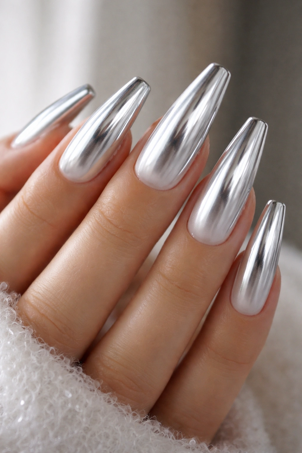 Close-up of icy chrome coffin nails over a milky base