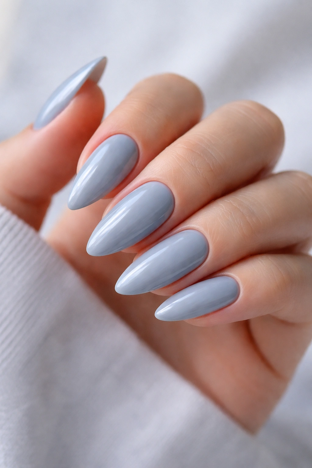 Close-up of icy gray almond nails with blue undertone and glassy shine
