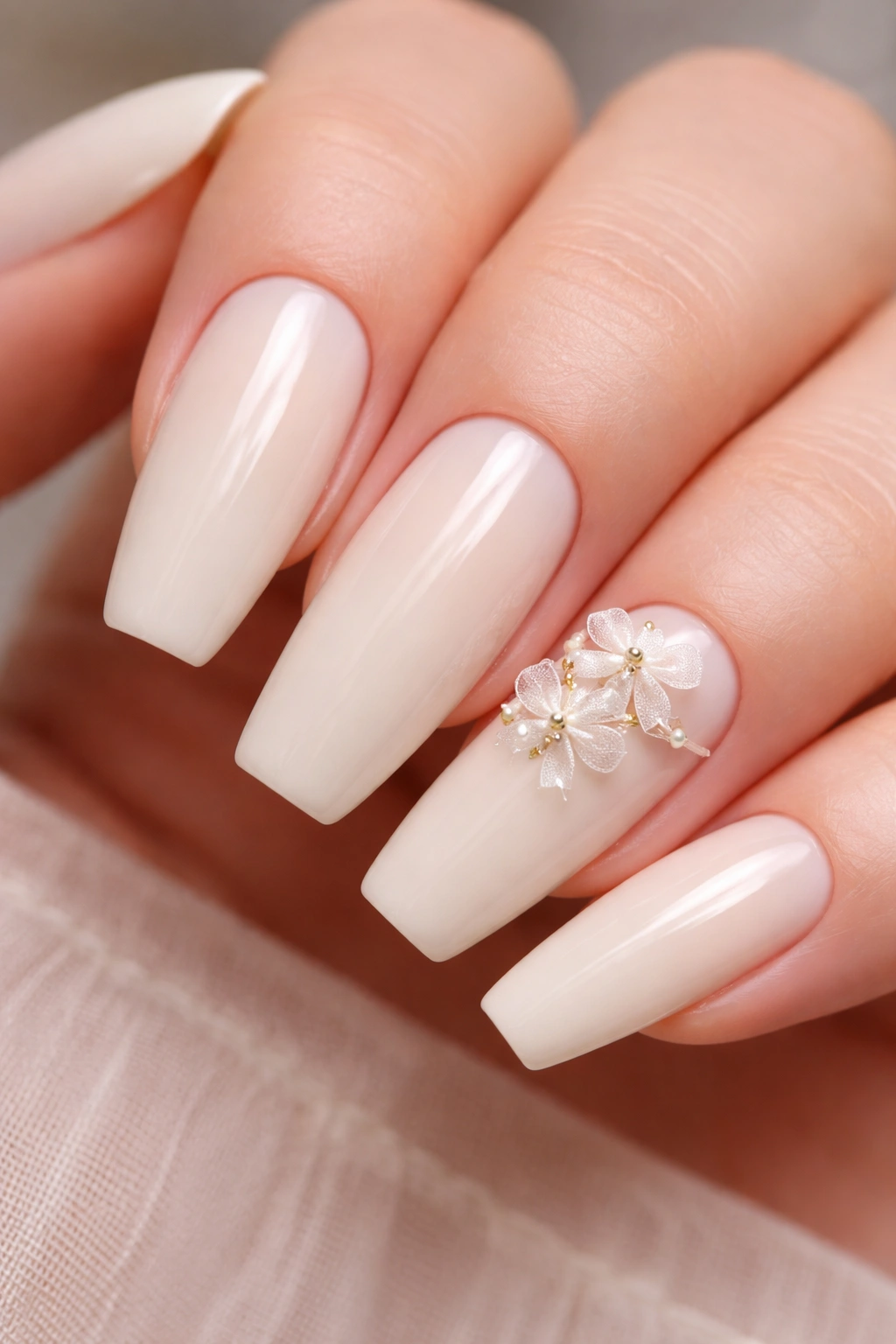 Close-up of creamy ivory nails with tiny bow bouquet accents