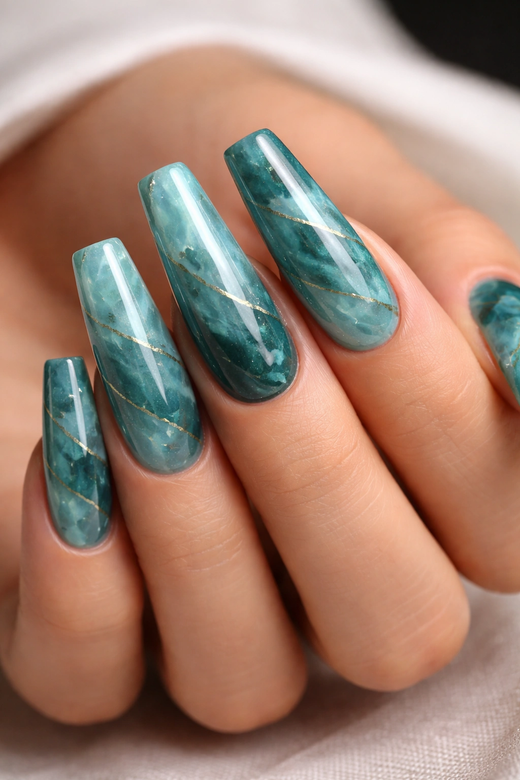 Close-up of coffin nails with jade-inspired teal marbling and subtle veining.