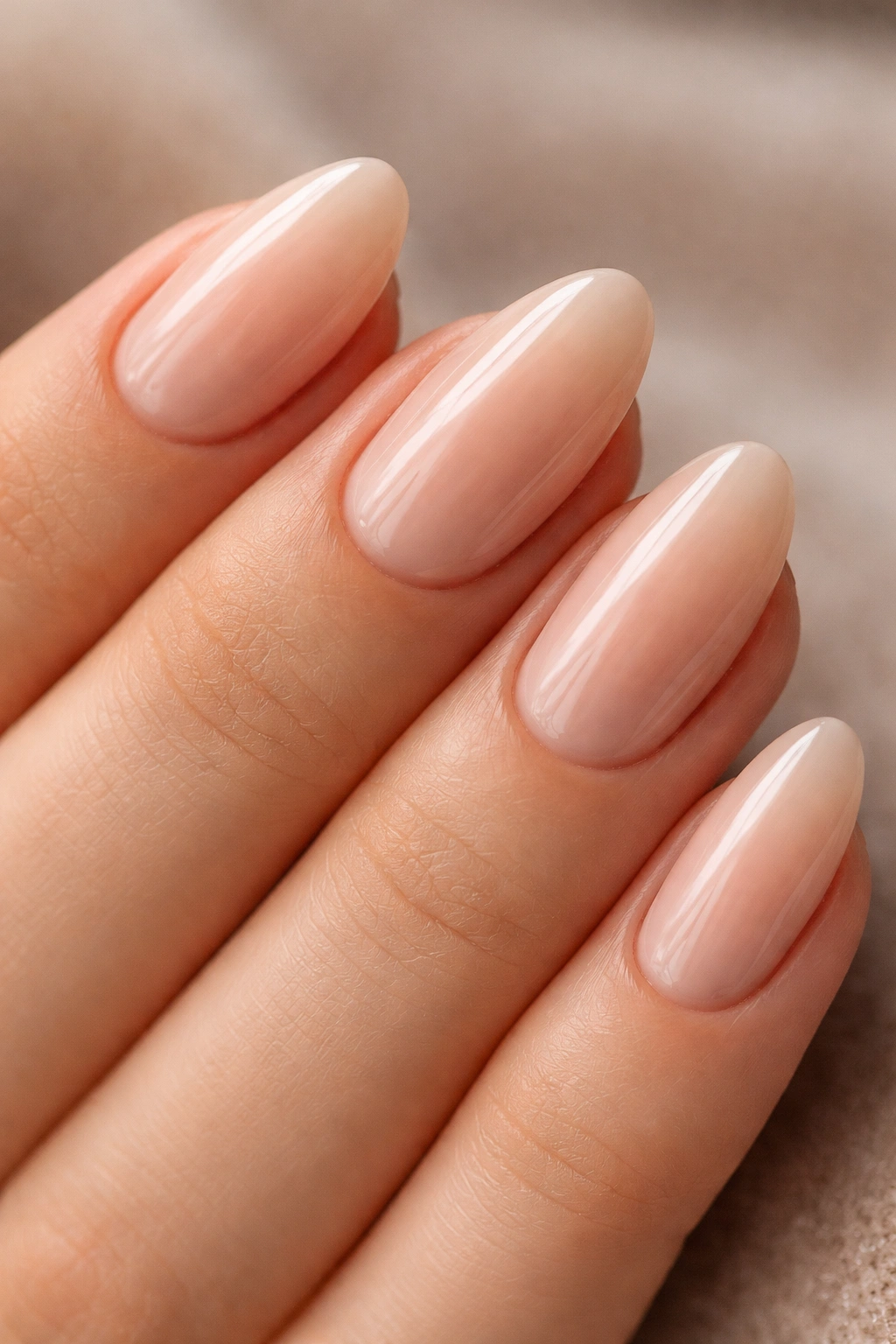 Close-up of beige almond nails with jelly finish translucent look