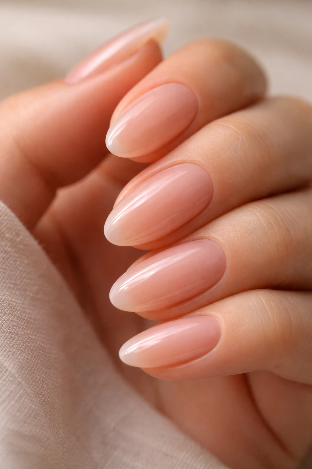Close-up of jelly nude almond nails showing translucent depth and glossy shine.