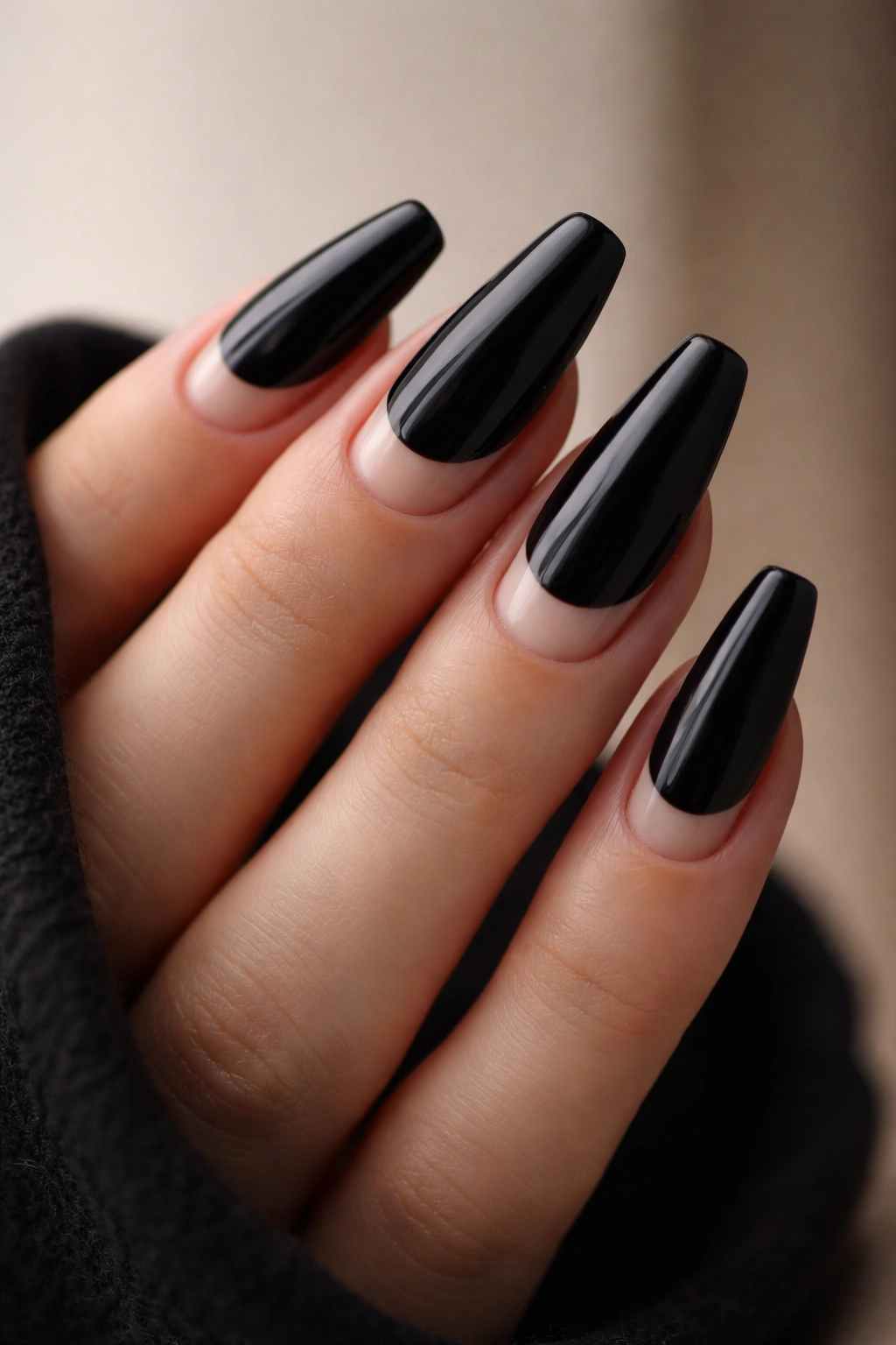 Close-up of jet-black medium coffin nails featuring crescent negative-space at the cuticle