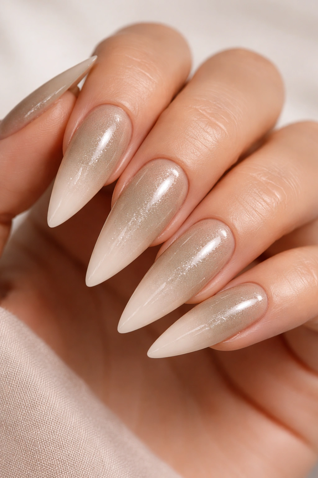 Khaki-to-cream ombre stiletto nails with subtle shimmer.