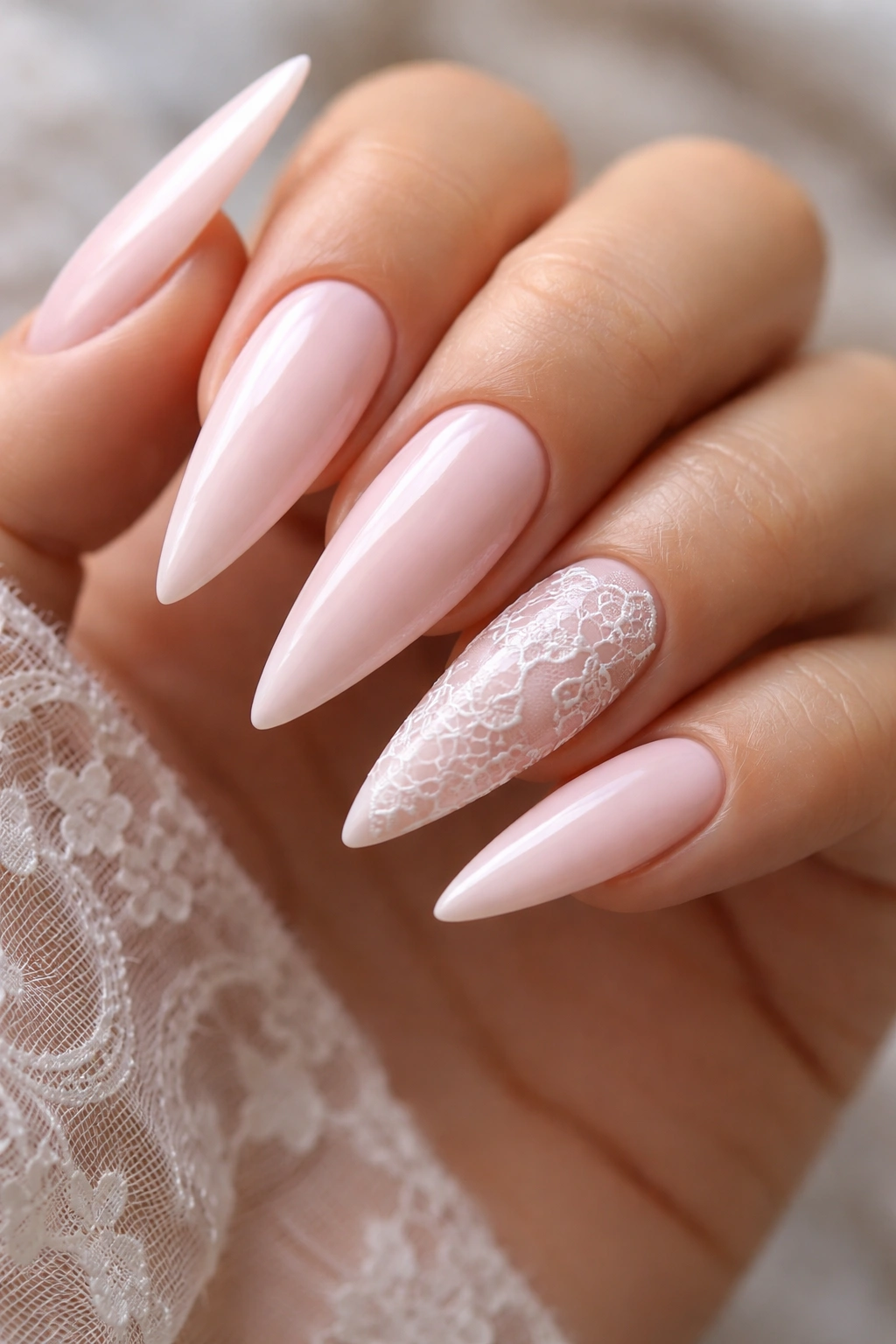 Close-up of light pink nails with delicate white lace accent nails