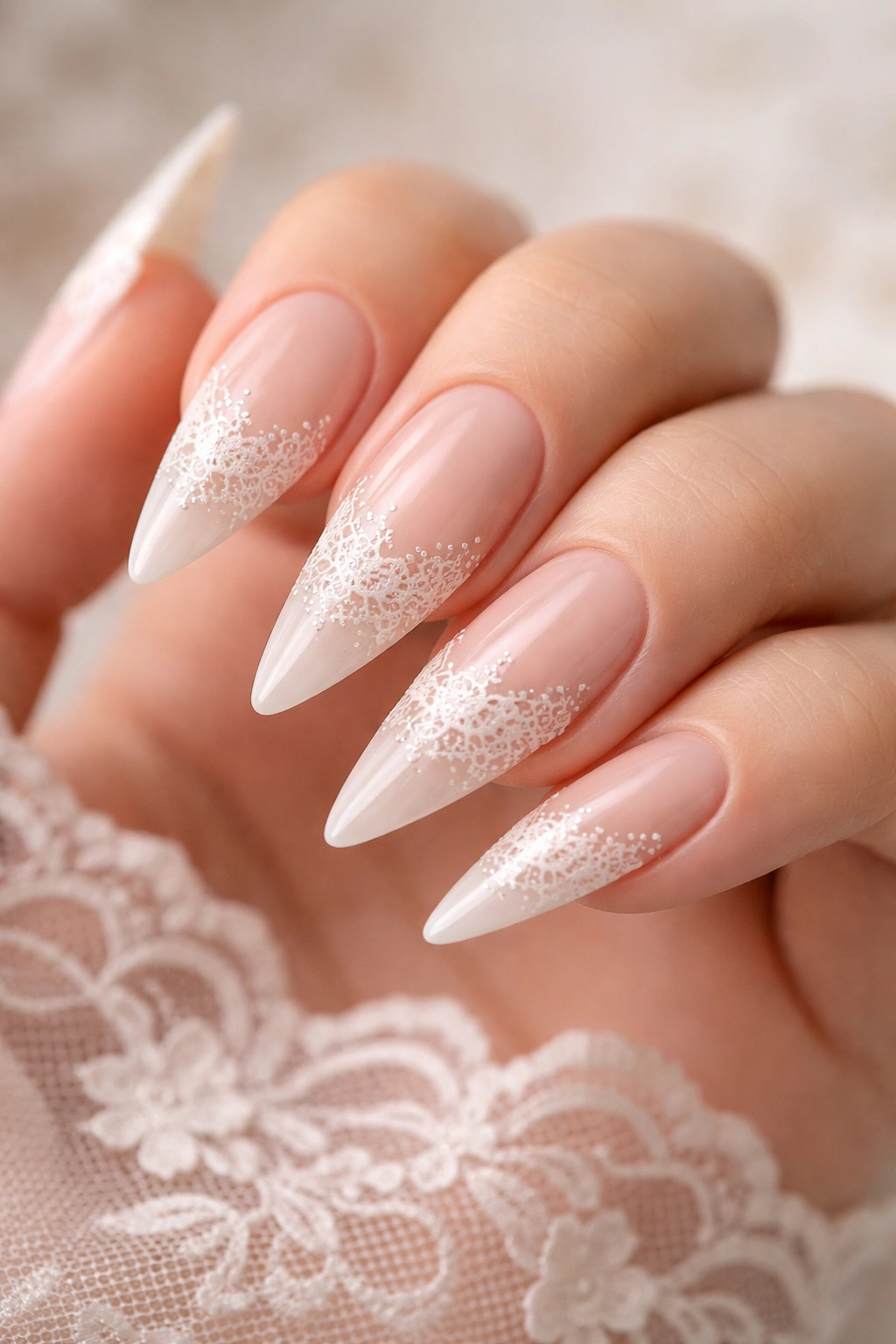 Nude stiletto nails with delicate white lace pattern