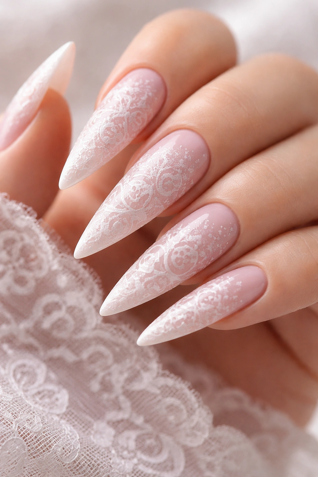 White lace stamped pattern on soft pink gel stiletto nails