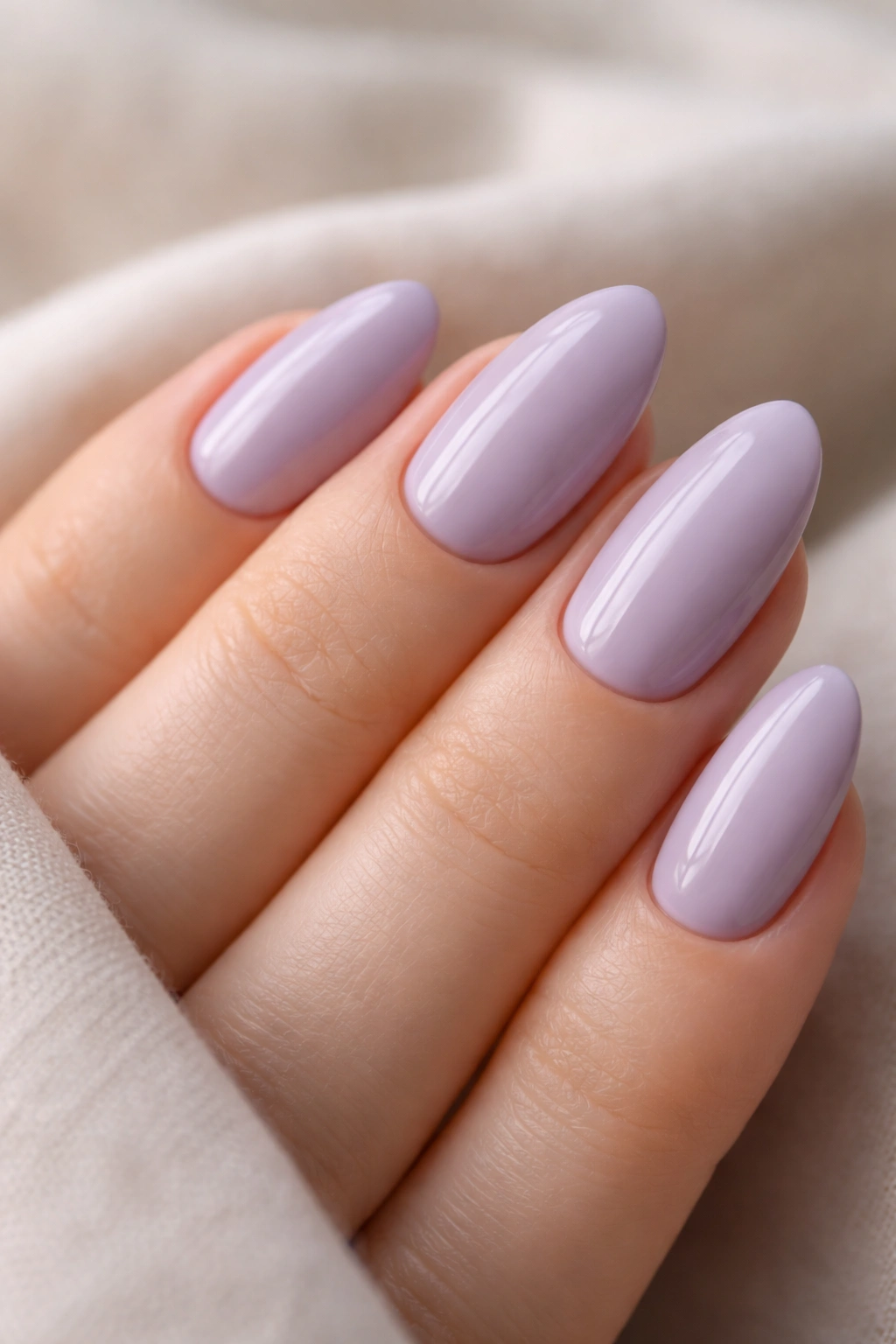 Close-up of short almond nails painted lavender with gray undertone