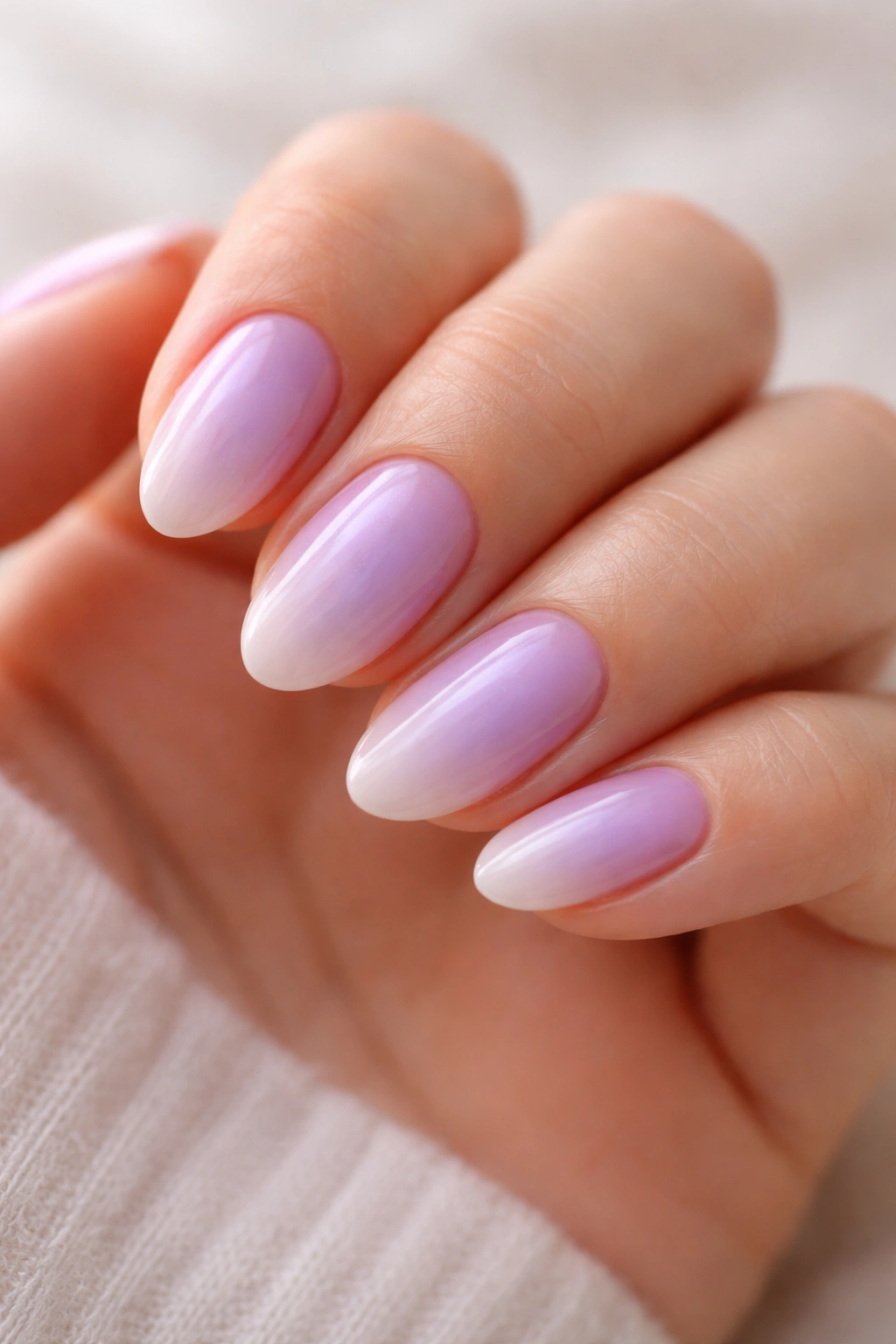 Close-up of lavender aura nails on short almond nails with soft glow.