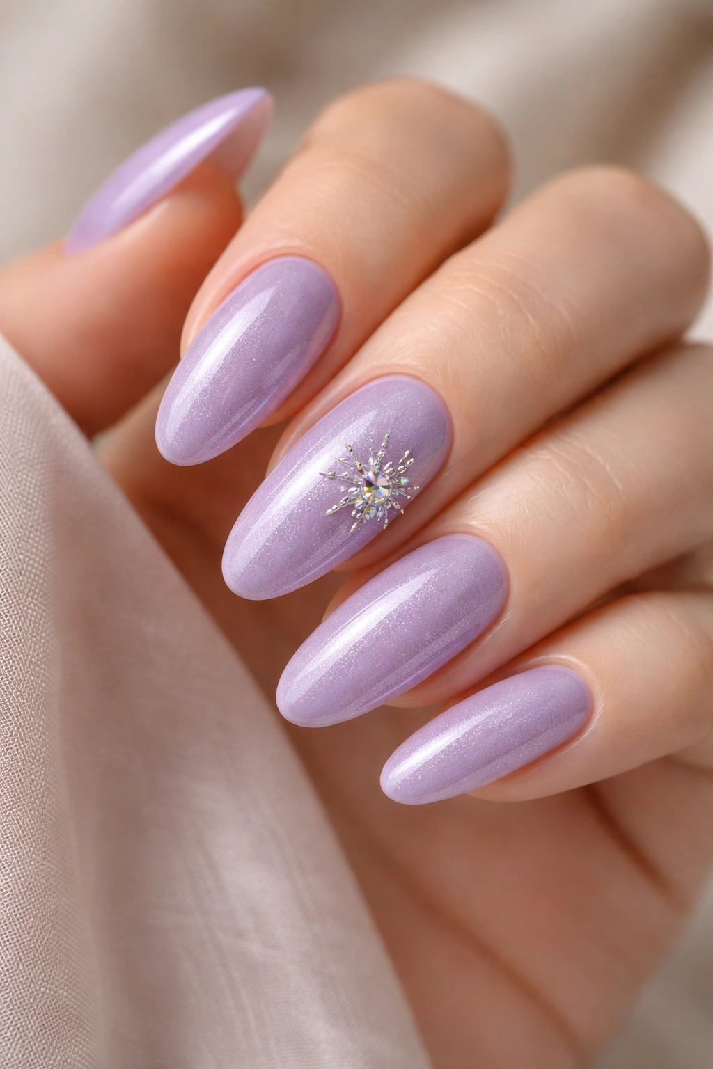Lavender cat-eye nails with a starburst crystal placement on an off-center nail
