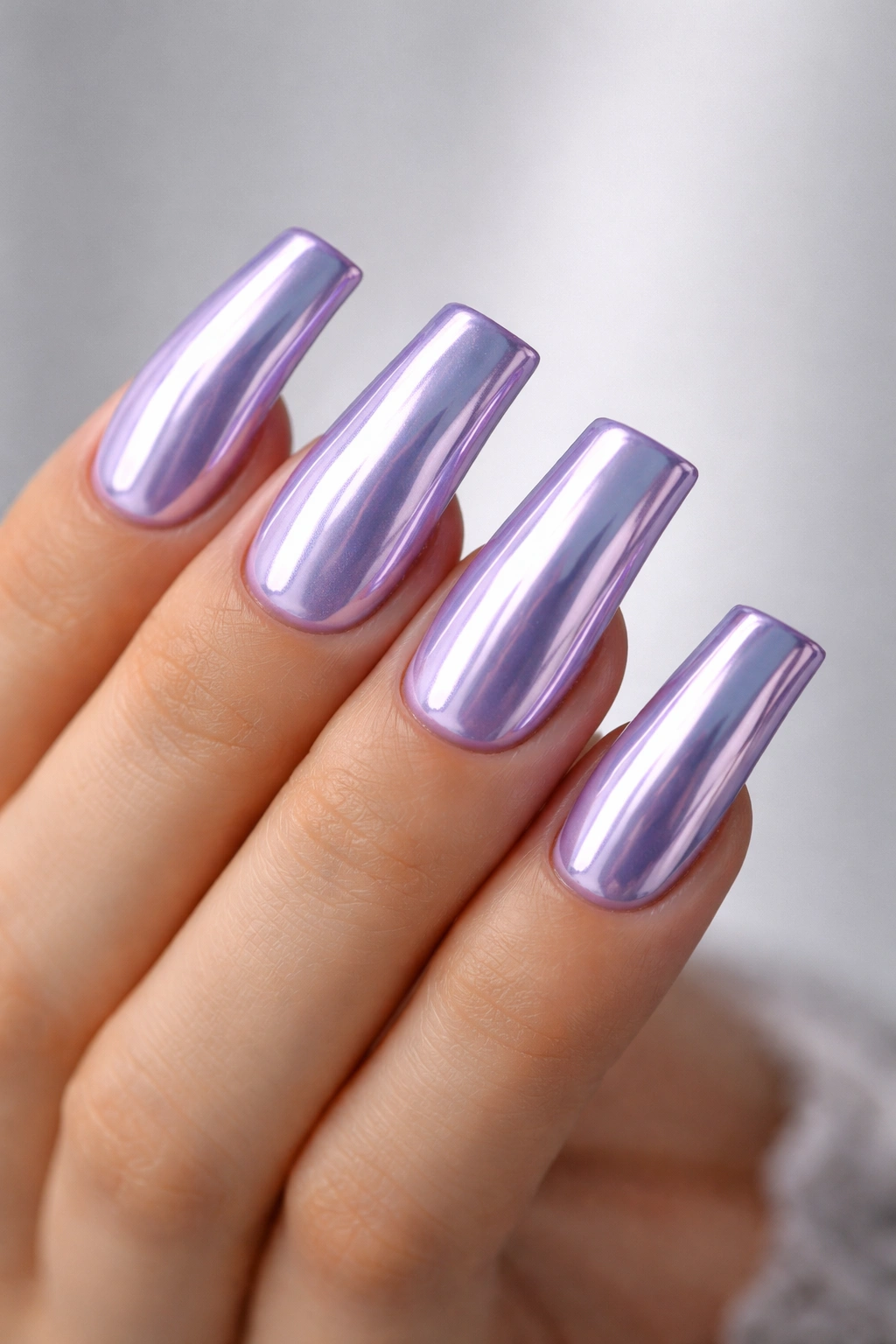 Close-up of lavender duck nails with chrome finish reflecting light