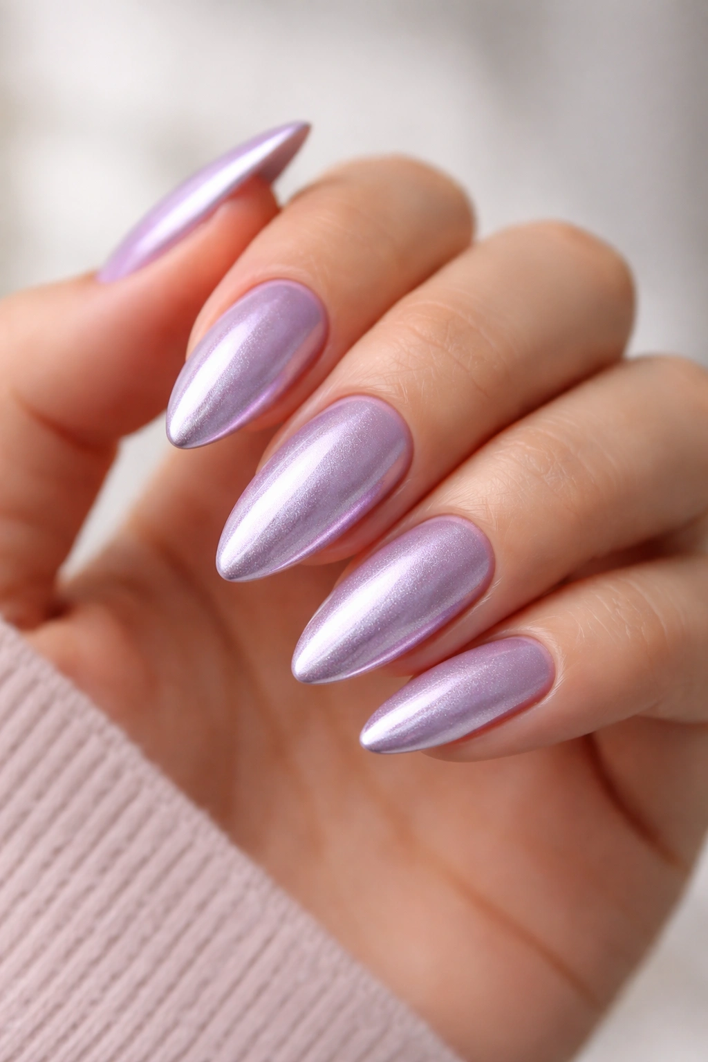 Close-up of lavender chrome almond nails with lilac-silver shimmer