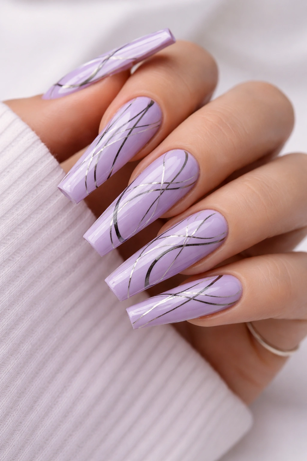 Close-up of lavender nails with abstract line art
