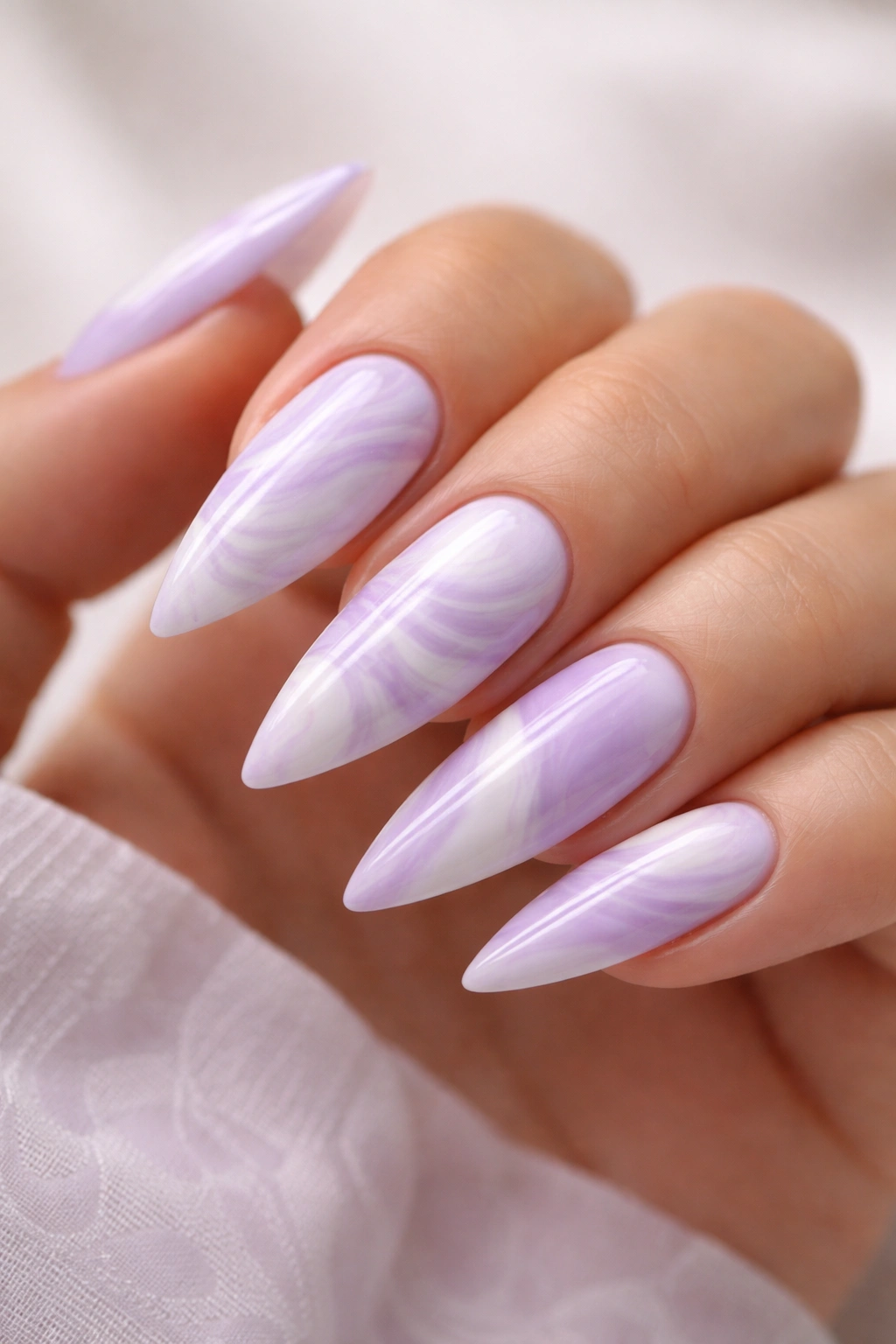 Lavender and white marble nails on medium stiletto nails with swirling pattern