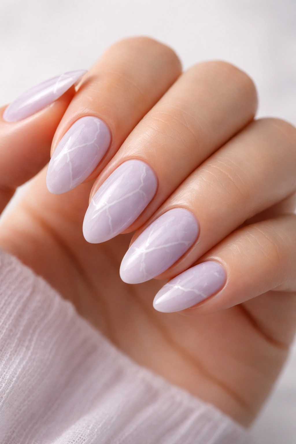 Close-up of lavender and white marble nails on short almond nails.