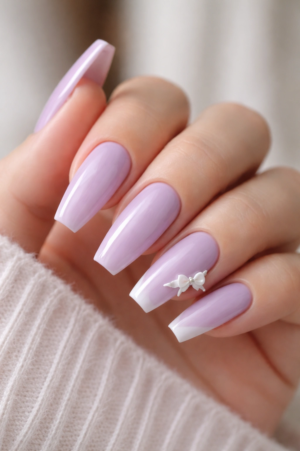 Close-up of lavender ballerina nails with bow French corners on two nails