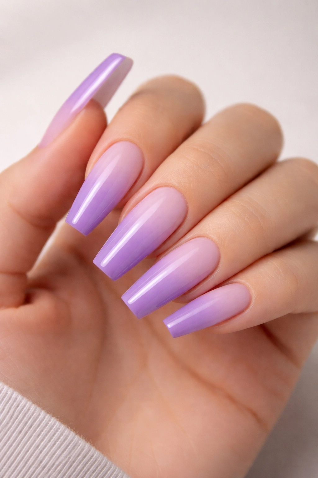 Close-up of long coffin nails with pale-to-deep lavender ombre