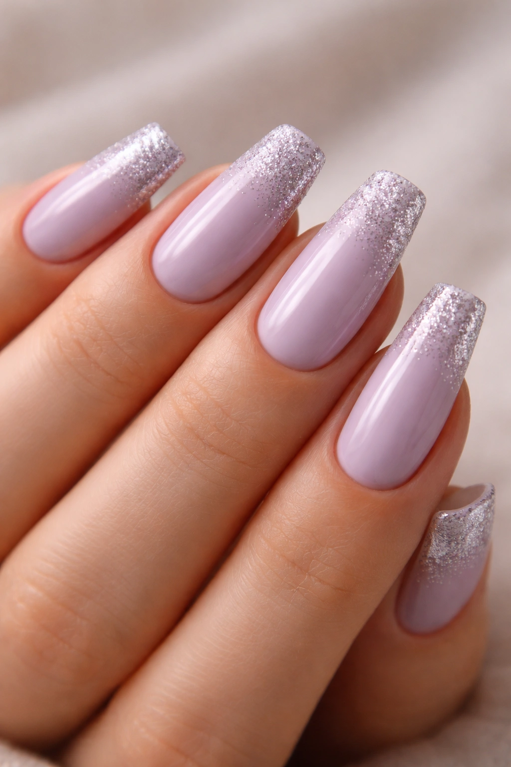Close-up of coffin nails in lavender with glitter tip gradient