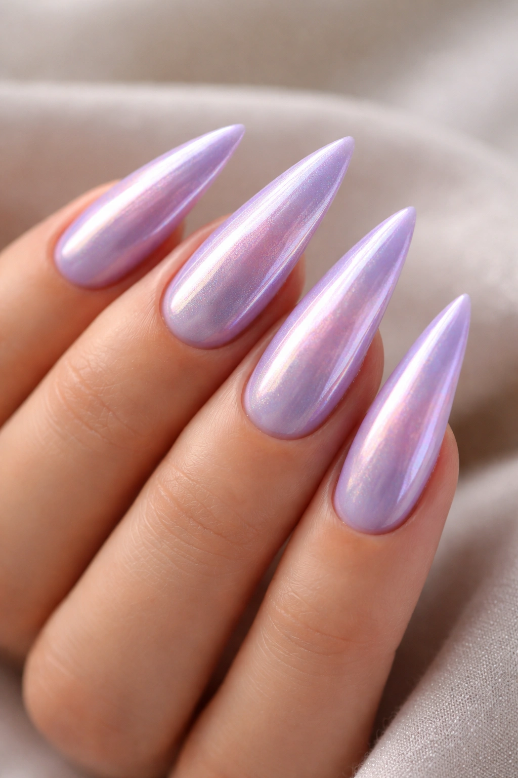 Close-up of lavender stiletto nails with a pearl finish