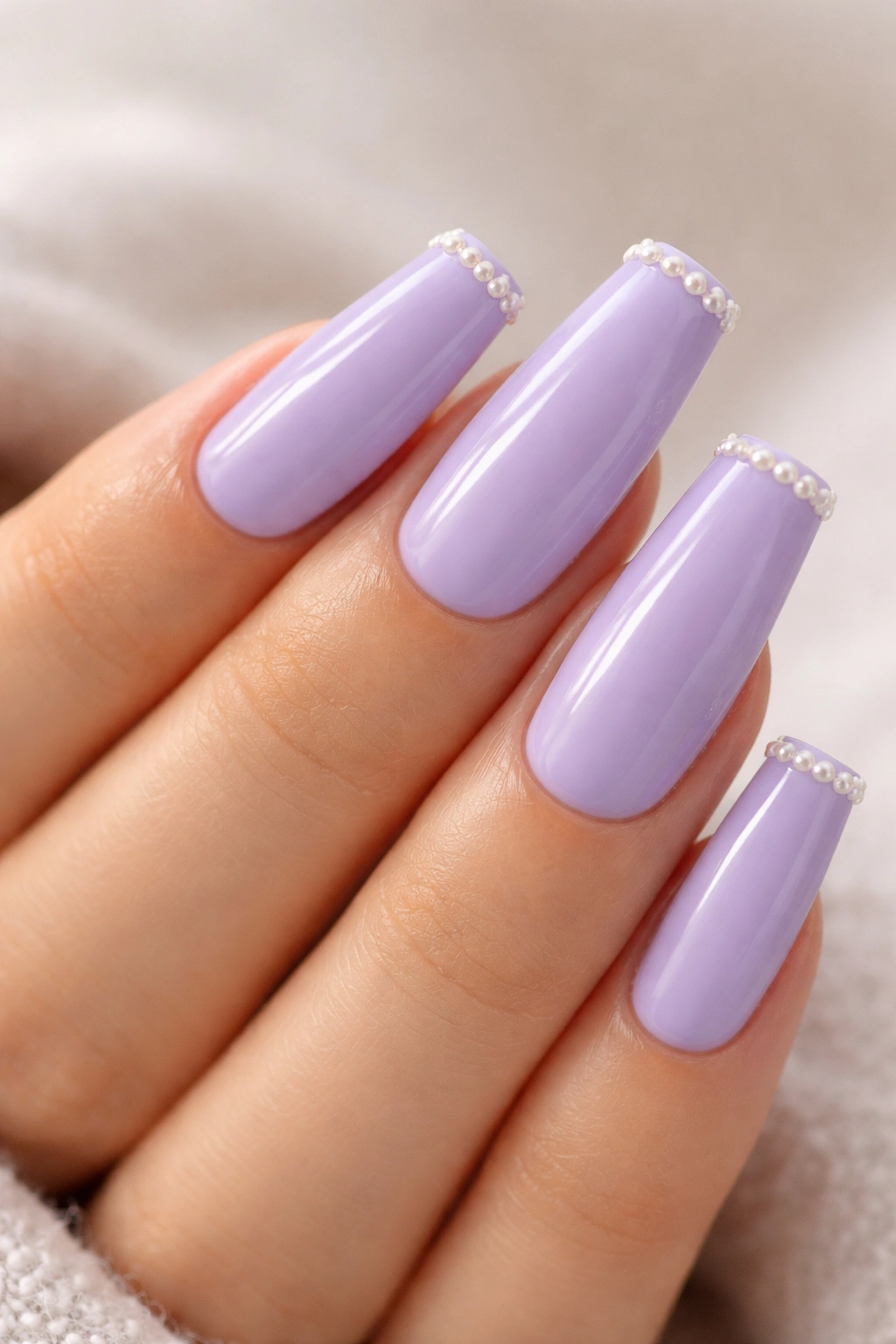 Coffin nails with lavender polish and small pearl beads at tips