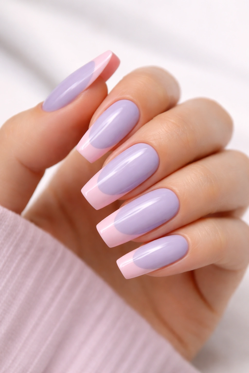 Close-up of lavender nails with soft pink French tips and glossy finish.