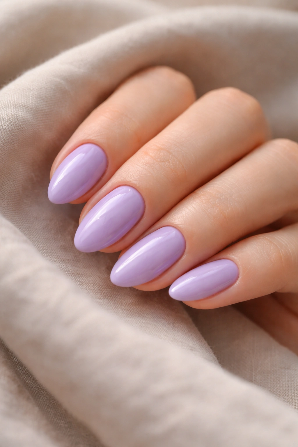 Close-up lavender nails on short almond shape with glossy finish