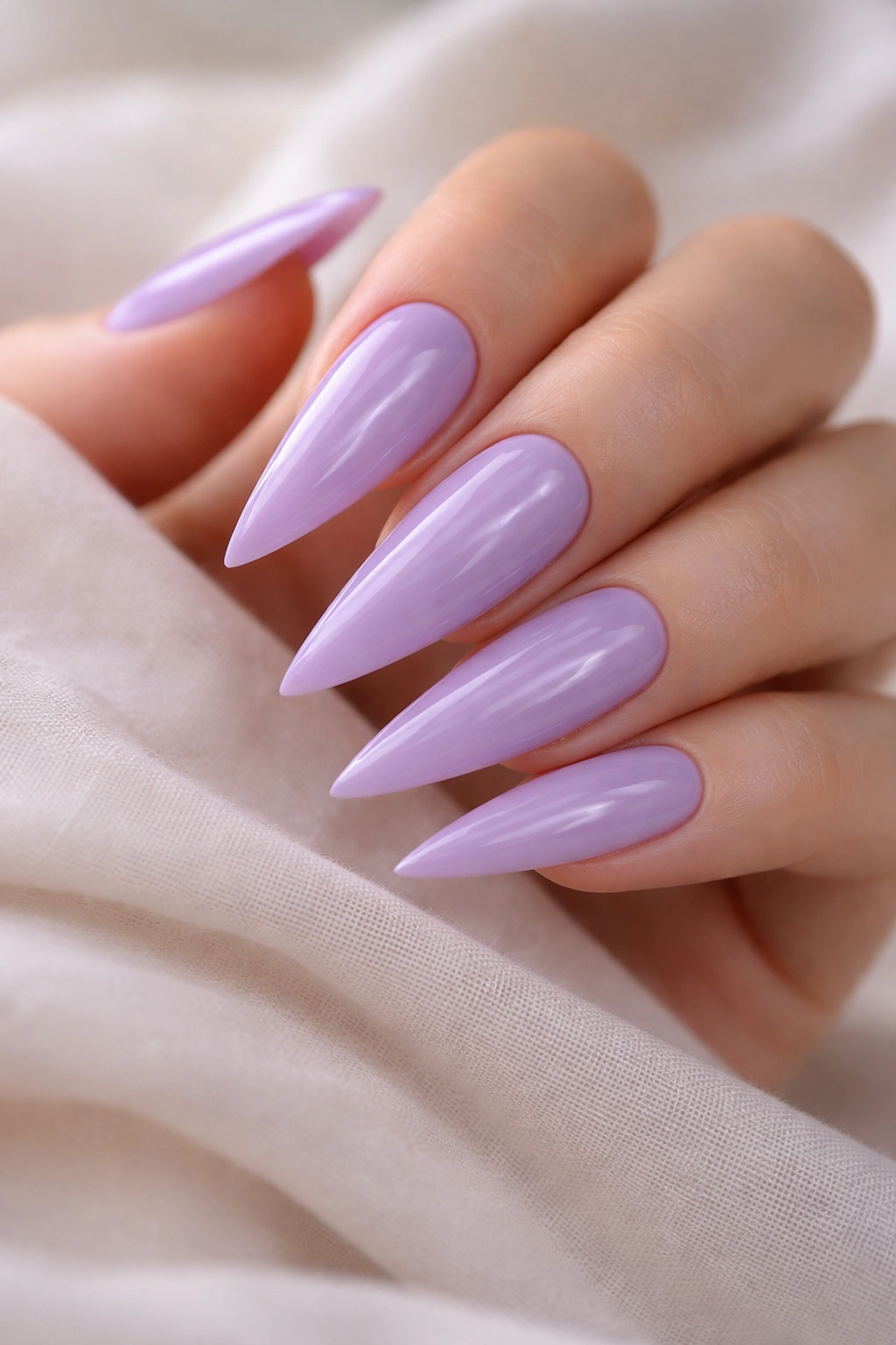 Close-up of lavender stiletto nails with a glossy finish and sharp edges