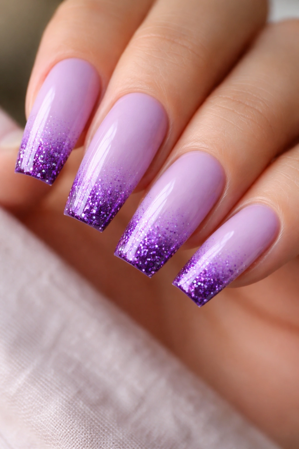 Close-up of lavender nails with purple ombre and glitter tips