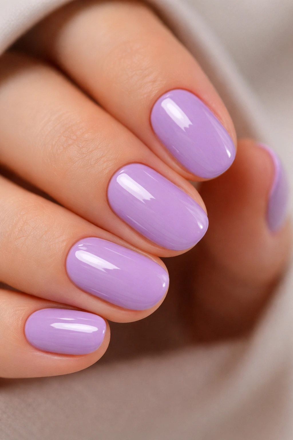 Close-up of lavender purple short oval nails with glossy finish