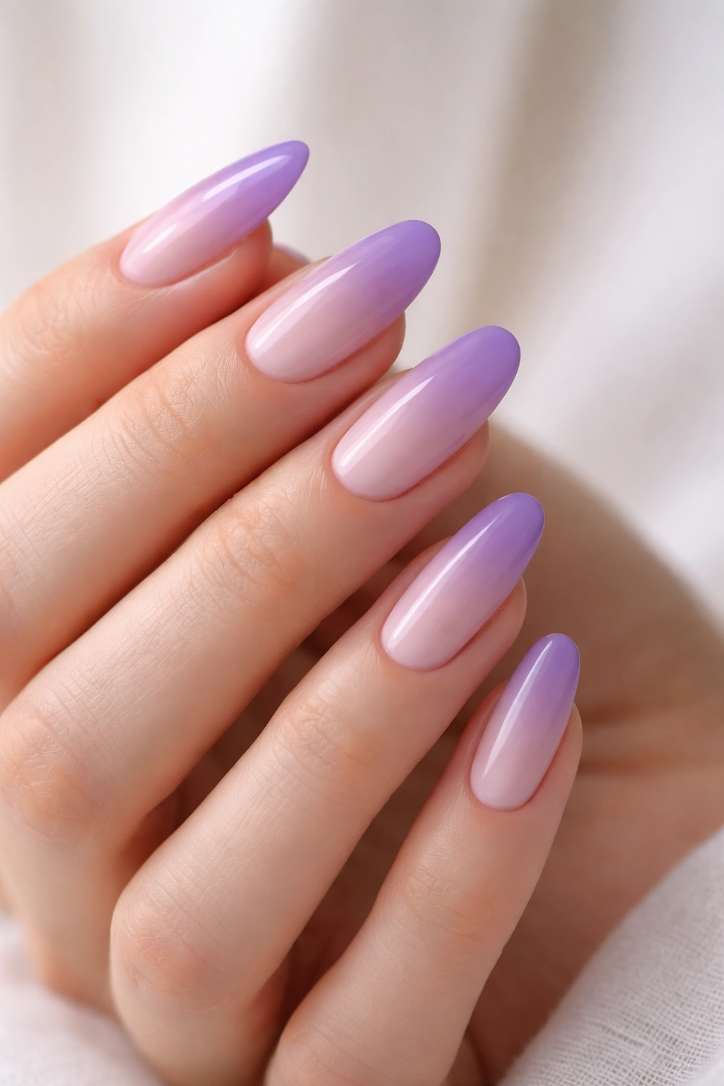 Close-up of long oval nails with lavender to violet ombre