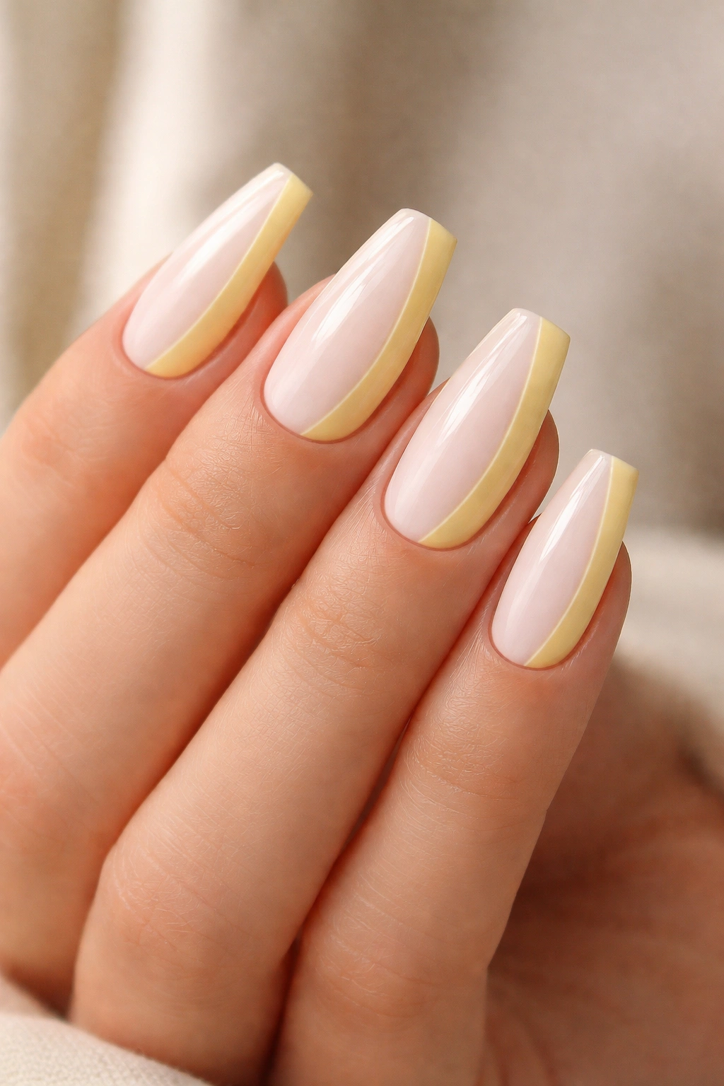 Close-up of lemon cream color-block nails on a hand