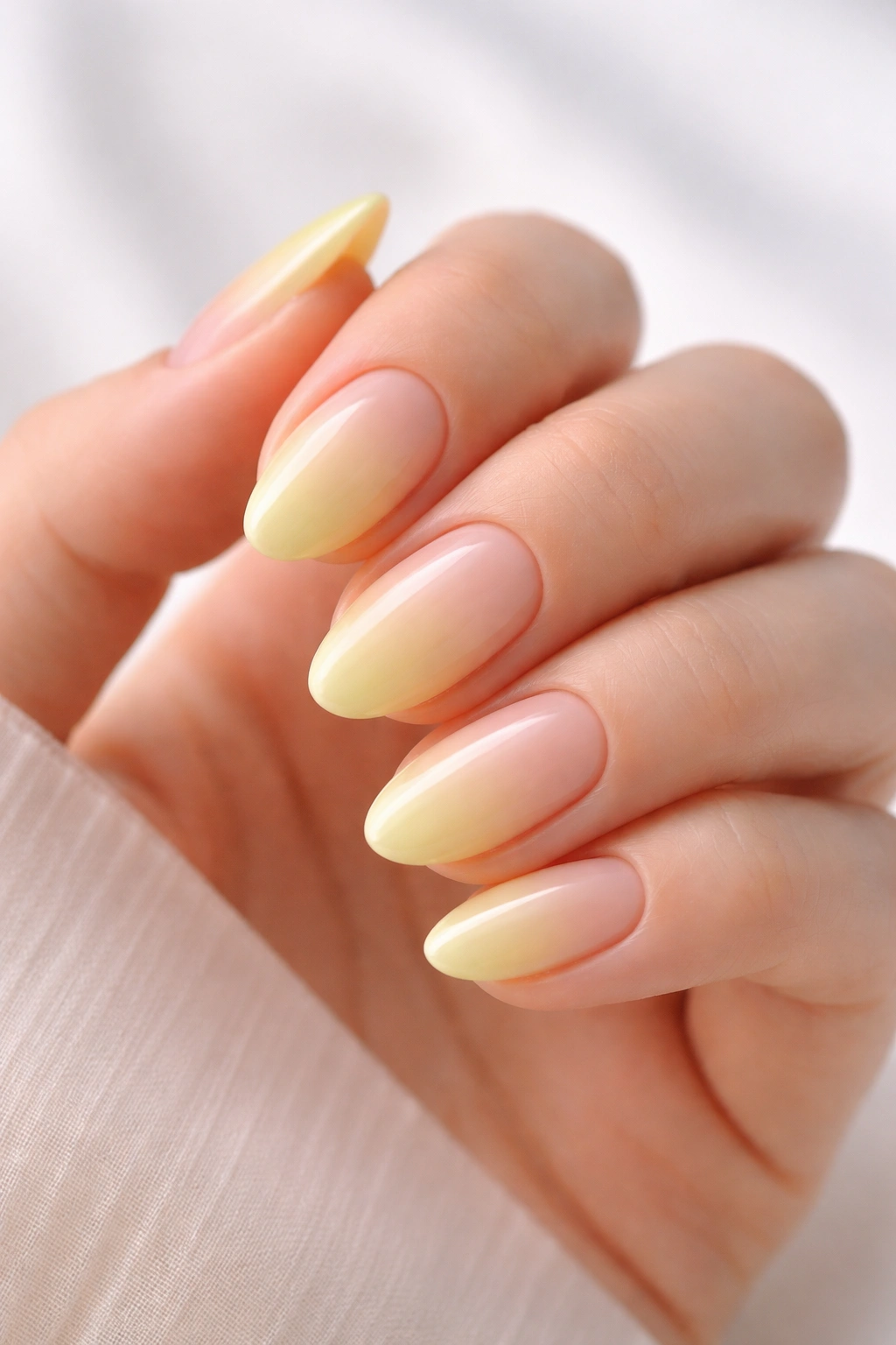 Close-up of short almond nails with lemon sorbet ombre