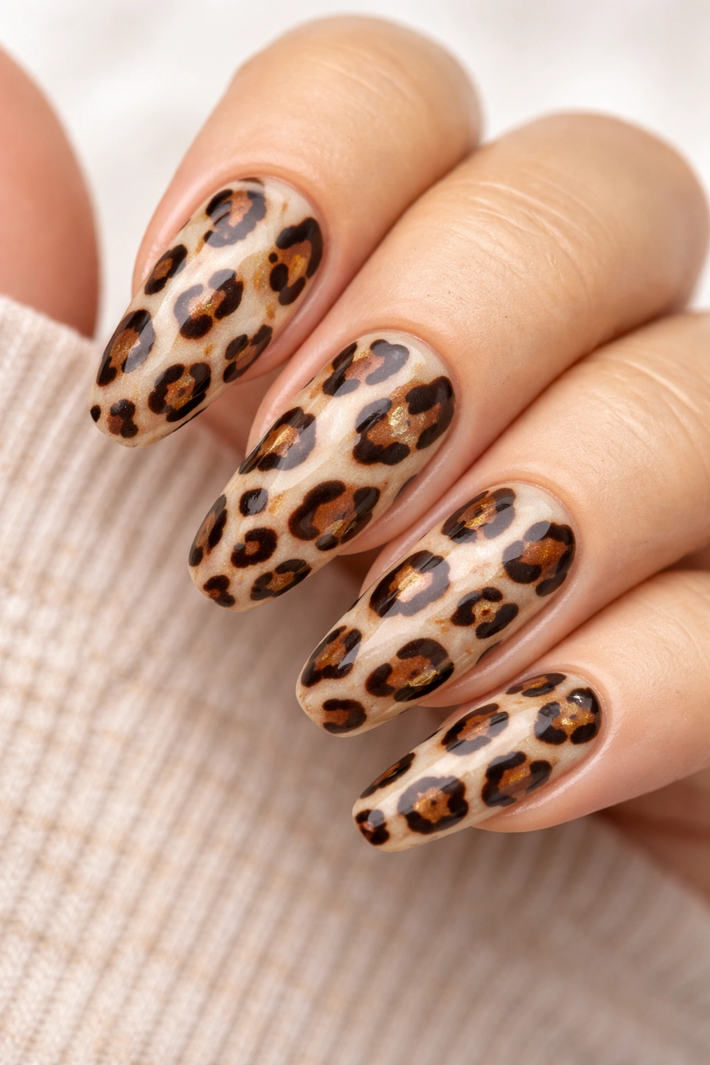 Close-up of leopard print nails with brown, tan, and black spots